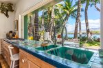 One of a kind kitchen and outdoor dining area looks out on sunny Kohala Coast